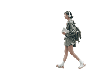 Young woman walking with headphones and books