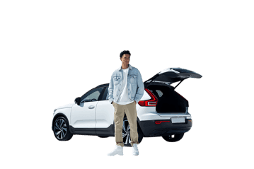 Man standing by his white SUV with open trunk.