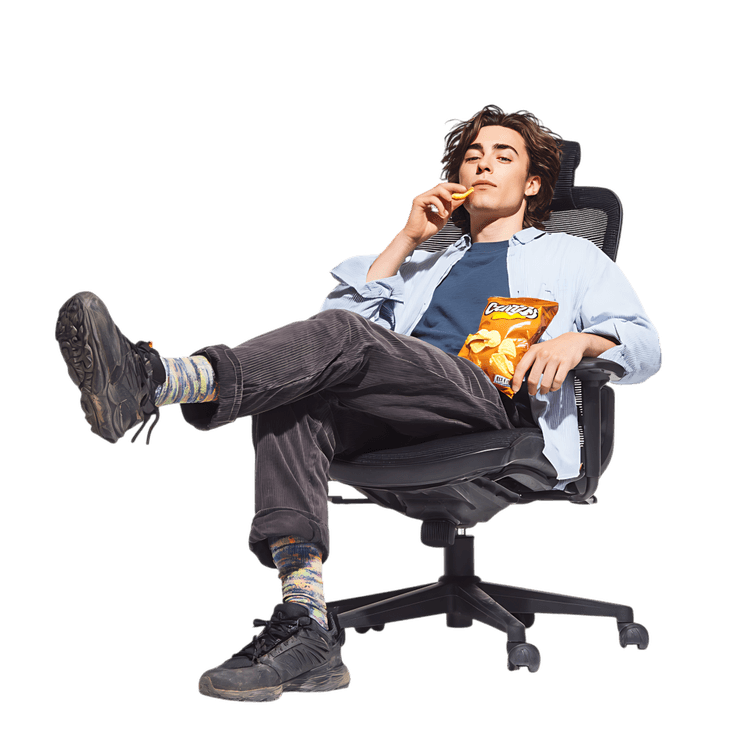 Man enjoys chips while relaxing in a chair.