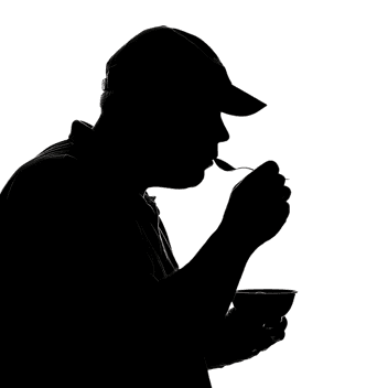 Dark silhouette of a man eating a meal, concept of hunger or dining.